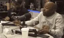 Two men laughing hysterically at a podcast table