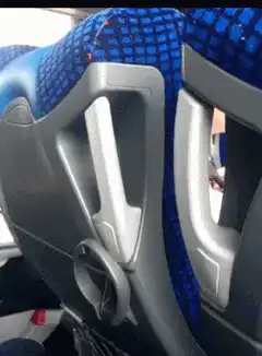 Boy peeking from behind bus seat