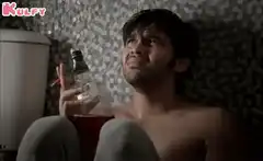 Shirtless man holding bottle and cigarette