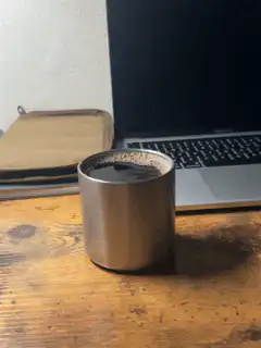 Coffee cup on desk next to laptop