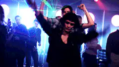 Woman dancing on man's shoulders at a party