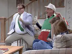 Two men cheering excitedly on a couch