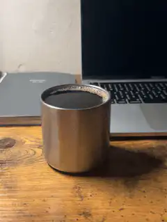 Metal cup on wooden desk