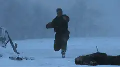 Man running and shooting in snow
