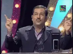 Indian game show host gesturing with hands