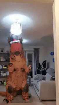 Two inflatable t-rex costumes dancing
