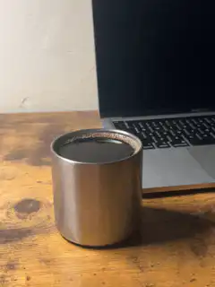 coffee cup on desk next to laptop