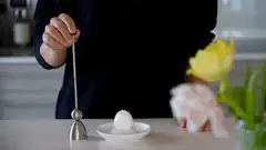 Person using an egg topper