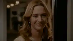 Kate Winslet smiling and walking through a doorway