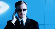 Agent Smith adjusting sunglasses