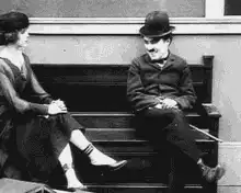 Charlie Chaplin sitting on a bench