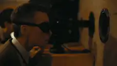 Man in sunglasses watches laser beam