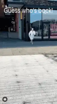 Man in white robe running outside