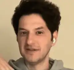 Man with earbuds reacting with shock