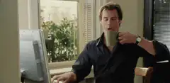 Hugh Grant drinking coffee and laughing