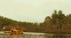 Person in canoe paddling on lake