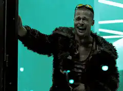 Brad Pitt laughing in a fur coat