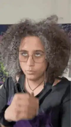 Girl with curly hair and glasses eating something