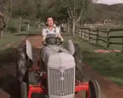 Woman driving a tractor on a dirt road