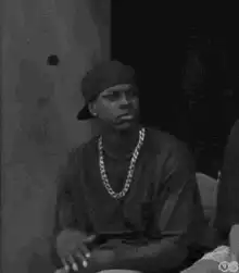 Man in beanie and chain looking skeptical
