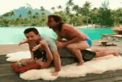 Three men in a human pyramid by a pool