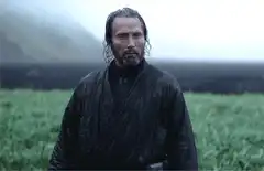 Mads Mikkelsen standing in a field