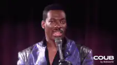 Eddie Murphy raising hand on stage