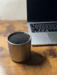 steaming coffee cup next to laptop