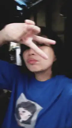 person making peace sign over eye