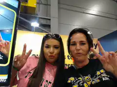 Two women posing with peace signs at a convention