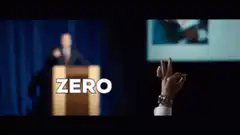 Man at podium says zero while hand gestures