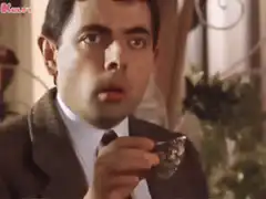 Mr. Bean eating a grape with wide eyes