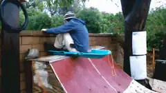 Person sliding down ramp on sled