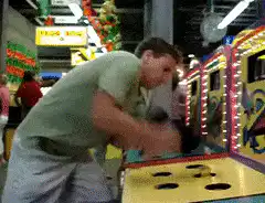 Man playing Whac-A-Mole arcade game