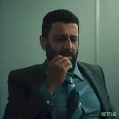 Man in suit facepalms