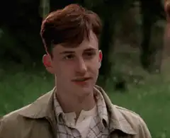 Dylan Minnette smirking and looking down