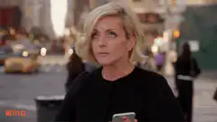 Jane Lynch points and makes a peace sign