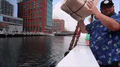 Man throws large package off boat