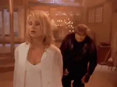 Woman singing while man dances in background