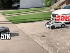 Bald man in red toy car crashes into white toy car