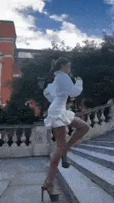 woman in white dress dancing on stairs