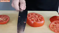 Knife slicing through tomato