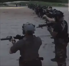 Soldiers firing rifles in a line