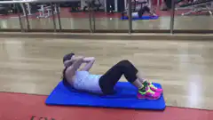 Woman doing crunches on blue mat