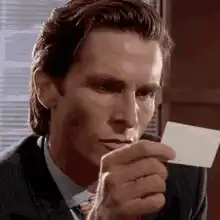 Patrick Bateman holding a business card