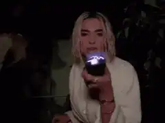 Billie Eilish holding a glowing orb
