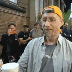Man raises a beer to the camera