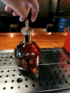 Hand opening a bottle of liquor