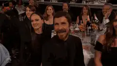 Christian Bale laughing at a dinner table