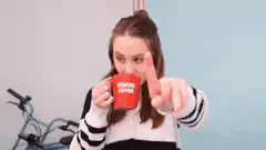 Woman drinking coffee and pointing